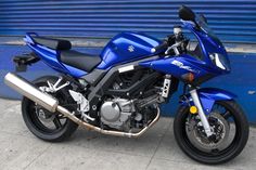 a blue motorcycle parked in front of a building