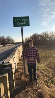 a man standing next to a street sign