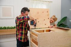 a man and woman are working on some wood