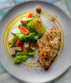 a white plate topped with chicken and salad