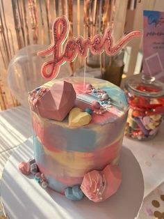 there is a cake that has the word love on it and candy in front of it