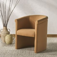 a brown chair sitting next to a vase on top of a carpet