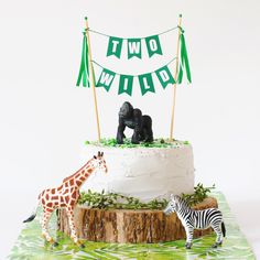 a zebra and giraffe standing next to a cake