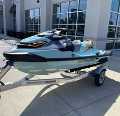 a blue and black jet ski boat parked in front of a building