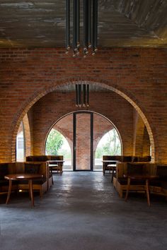 the inside of a brick building with benches and tables