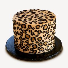 a leopard print cake sitting on top of a black plate