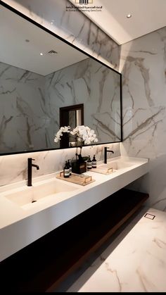 a bathroom with two sinks and a large mirror