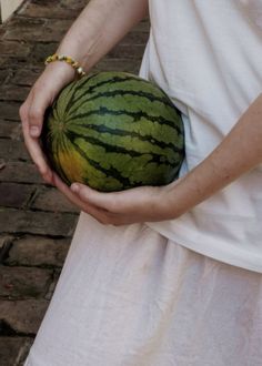 a person holding a watermelon in their hands