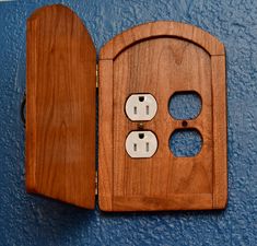 a wooden wall outlet with two outlets in the middle and one on the other side