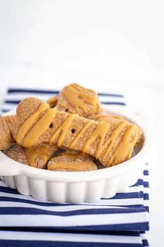 peanut butter pretzels in a white bowl on a blue and white striped napkin