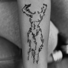 a black and white photo of a woman's leg with flowers on it