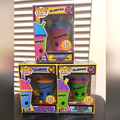 three boxes of surprise pop toys sitting on top of a black table in front of a window