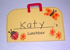 a yellow lunchbox with ladybugs on it and the name kathy's lunchbox