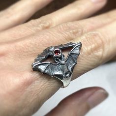 These tiny bats make a dramatic ring. Carrie carved the model for this ring in wax, then cast it in Silver. Mozambique Garnet adds the perfect orangey red pop of color. The top measures 27mm x 19mm and the band is 4mm wide. This ring is a size 7. *Please contact me if you would like to order a size other than what is available. Unique Hand Cast Rings For Halloween, Vampire Wardrobe, Blood Ring, Afro Jewelry, Vampire Ring, Bat Ring, Goth Ring, Bat Jewelry, January Birthstone Rings