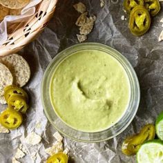 a glass bowl filled with guacamole surrounded by chips and limes