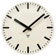 a large white clock with black hands and numbers on the face is shown against a white background