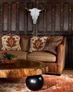 a living room filled with furniture and a cow skull mounted on the wall above it