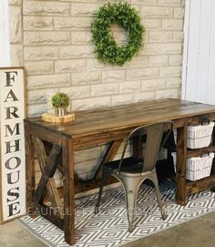 a wooden table sitting in front of a brick wall with a wreath on top of it