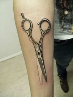 a tattoo on the leg of a person with a pair of scissors in front of them