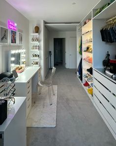 an empty room with lots of white furniture and shelves filled with shoes, handbags and purses