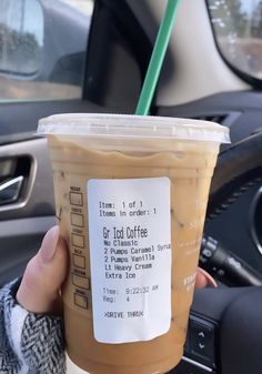 a person holding up a cup of iced coffee