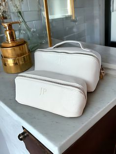 Beautiful faux leather lay flat makeup bags make the perfect gift for a bridesmaid proposal. Customise this bag with your choice of initials name. These make up bags are perfect for taking away on weekend trips or on holiday keeping all your makeup neat and tidy. Our makeup bags are available in 6 different colours. Features - Saffiano faux leather - Lay flat design - Available in 2 sizes - Available in 6 colours - Beautifully monogrammed initials or name - Soft touch lining - Zip closure - Multi-purpose use Dimensions Medium - 8 x 21 x 8 cm Large - 12 x 24 x 12 cm Material: 100% leather-look PU. Estimated Delivery date The estimated delivery date is based on your purchase date, the recipient's location, the seller's processing time and location, and the delivery carrier. Other factors -- Proposal Makeup, Monogram Cosmetic Bag, Makeup Organiser, Bridesmaid Makeup Bag, Custom Makeup Bags, Custom Makeup, Personalized Makeup Bags, Make Up Bags, Bridesmaid Makeup