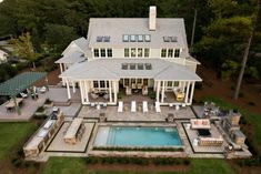 an aerial view of a large house with a pool in the front yard and covered patio area