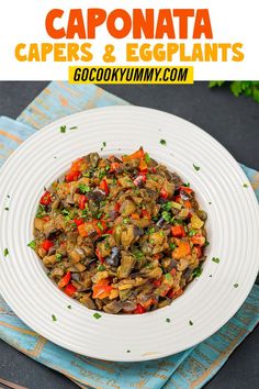 a white plate topped with cooked vegetables on top of a blue napkin