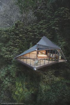 a small cabin in the middle of trees with a bed on it's roof