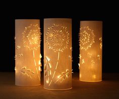 three lit up candles with flowers on them