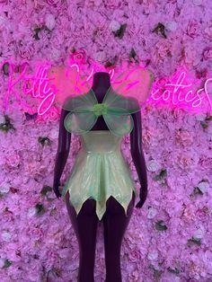 a mannequin dressed in a green dress and pink flowers