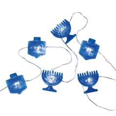 four blue hair combs sitting next to each other on a white surface with string lights