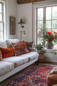 a living room filled with lots of furniture and flowers in vases on the windowsill