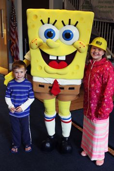 two children standing next to a spongebob mascot