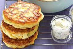 some food is sitting on a rack next to cups and bowls with dips in them