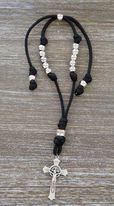 a black and white necklace with a silver cross on the front, beads around the neck