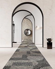 a long carpet with an arch in the middle and a round mirror on the wall