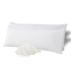 two white pillows and a pillow on a white background with a flower in the middle