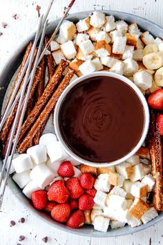 a platter filled with marshmallows, strawberries and chocolate