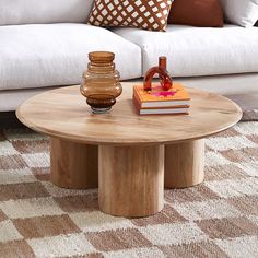 a living room with a white couch, coffee table and pillows on the carpeted floor