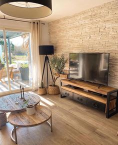 a living room filled with furniture and a flat screen tv on top of a wooden table