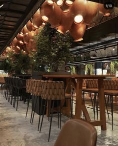 an empty restaurant with many chairs and lights hanging from the ceiling over it's tables