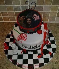 a cake decorated with two people on top of a checkerboard tableclothed surface