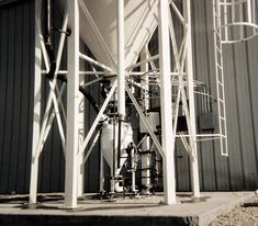 an industrial water heater is shown in black and white, next to a building