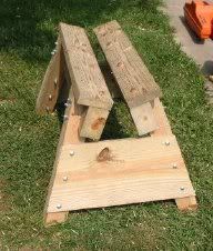 a wooden bench sitting in the grass next to a fire extinguishers