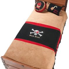 a pirate themed bed with a wooden box and pillow on it's headboard