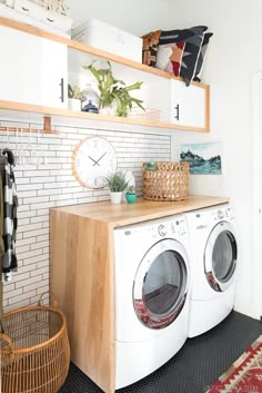 a washer and dryer sitting in a room next to a wall with shelves