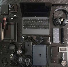 an assortment of electronics and gadgets are laid out on a table with headphones