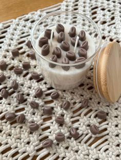 a glass bowl filled with chocolate chips on top of a white doily next to a wooden spoon