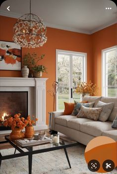 a living room with an orange wall and white fireplace in the center, surrounded by furniture